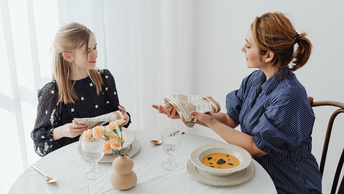 A mother and daughter share a meal, focusing on table etiquette and bonding over lunch.